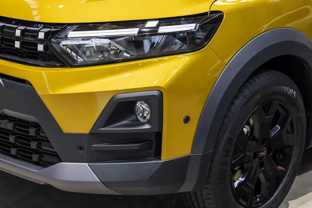 Dichtbij beeld van de voorste koplamp van een gele Suzuki S-Presso.