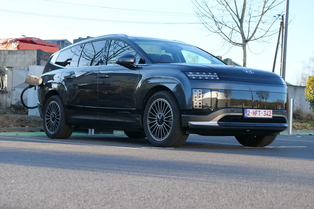 Hyundai Ioniq 7 noir se recharge dans une station, design futuriste et jantes en alliage.