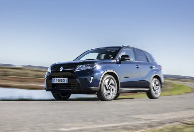 SUV Suzuki Vitara 2023 roulant sur une route sinueuse par temps clair.