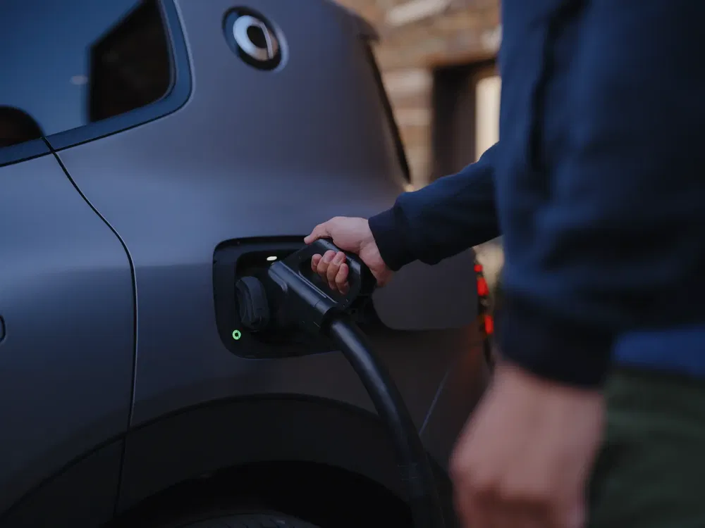 Elektrische auto wordt opgeladen met aansluitkabel, moderne compacte auto.