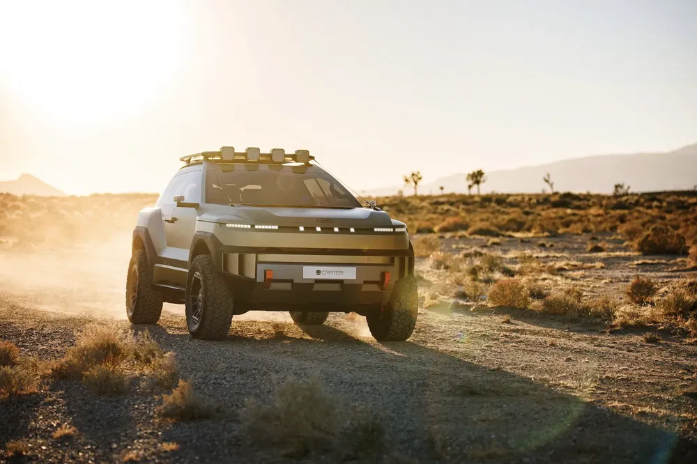 Concept car électrique tout-terrain Hyundai en plein désert, sous un soleil couchant spectaculaire.