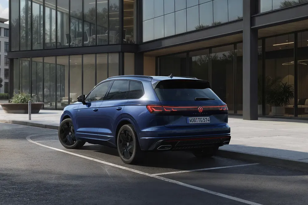Blauwe Volkswagen SUV geparkeerd voor modern gebouw, elegante achterkant en zwarte velgen.