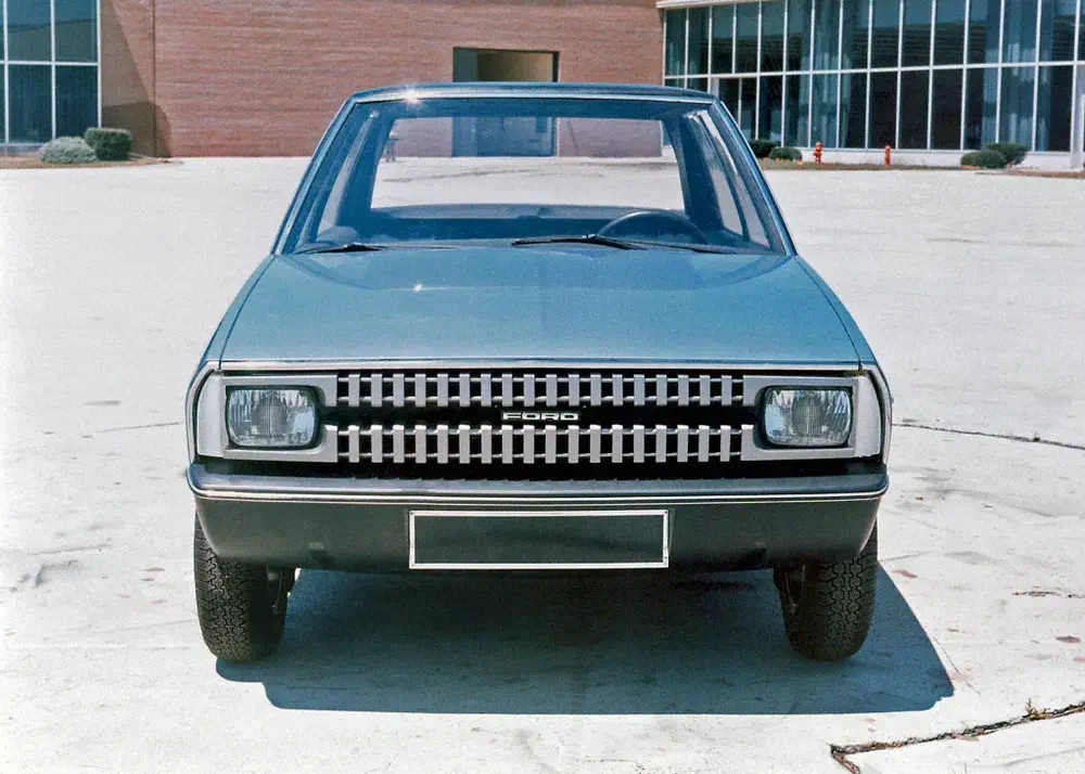 Voiture vintage Ford avec calandre distinctive garée devant un bâtiment moderne.