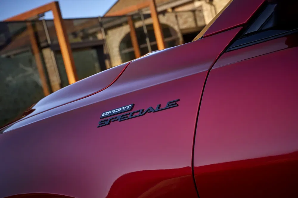 Zijkant van een rode auto met "Sport Speciale" badge in focus.