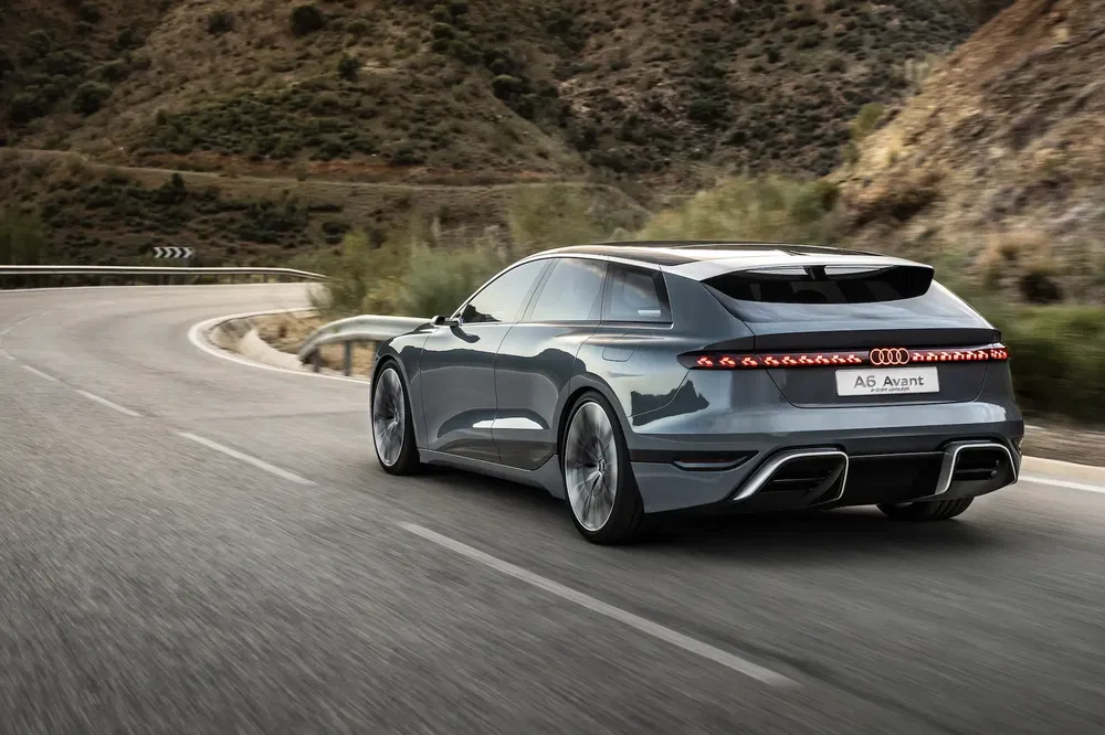 Audi A6 Avant électrique roulant sur une route sinueuse en montagne.