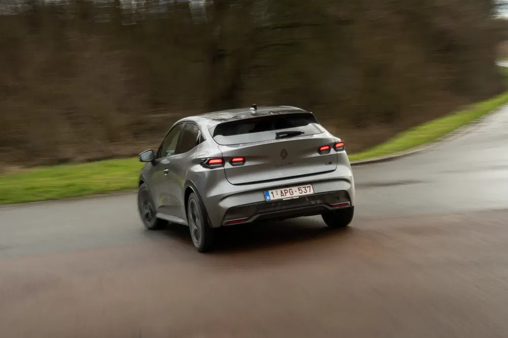 Zilveren Renault Mégane E-Tech op bochtige weg, achterkant met opvallende verlichting.