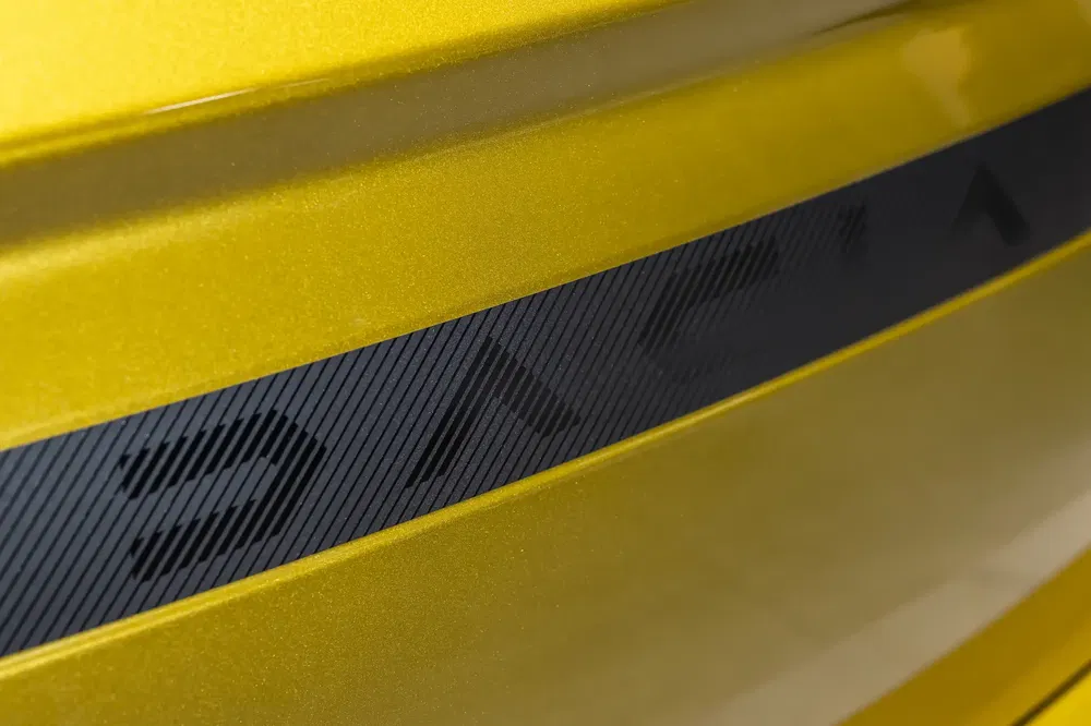 Geel carrosserie-detail van een Dodge Charger 2023 met een opvallende zwarte streep.
