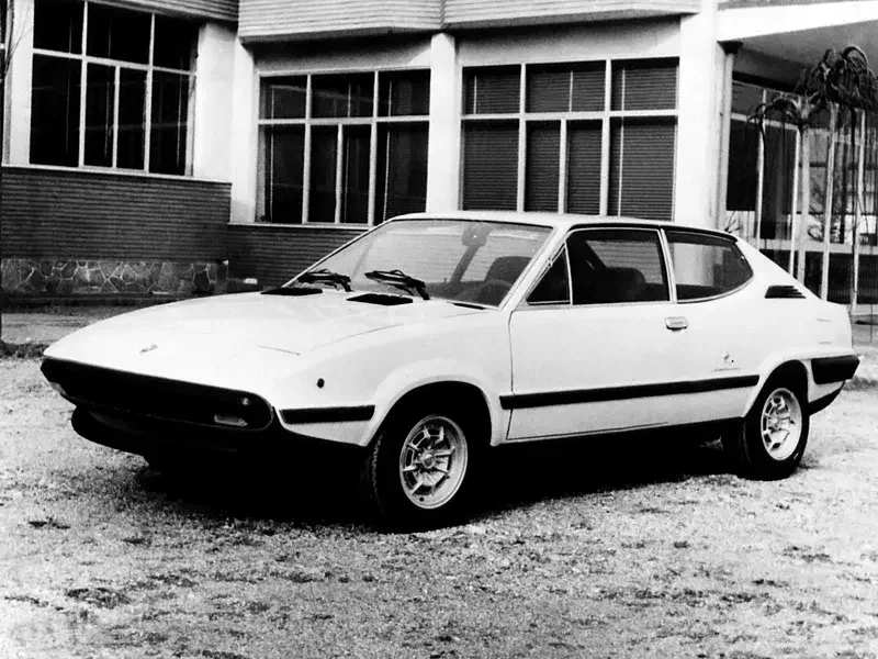 Lichte Volvo 1800 ESC geparkeerd voor een gebouw, jaren 1970 design.