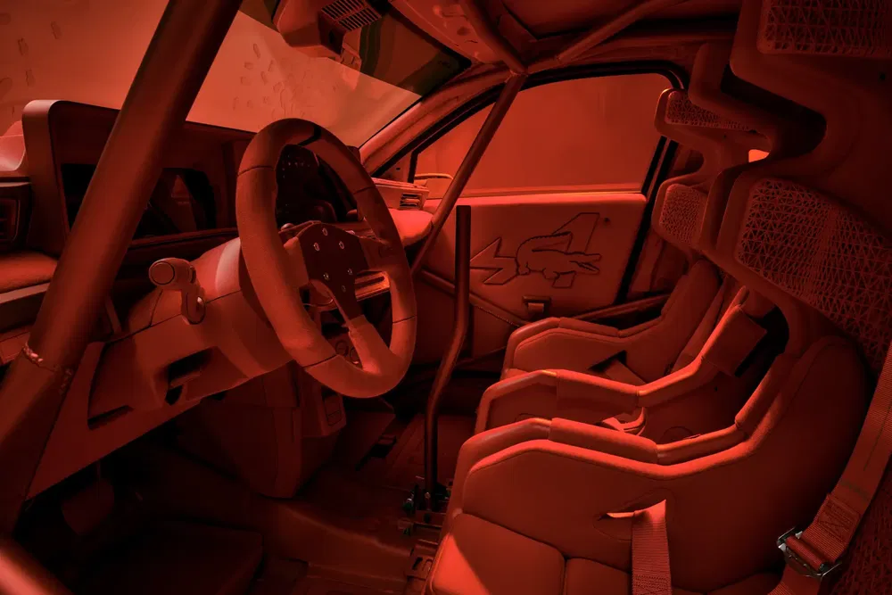 Intérieur de voiture de course avec sièges baquets rouges et arceau de sécurité.