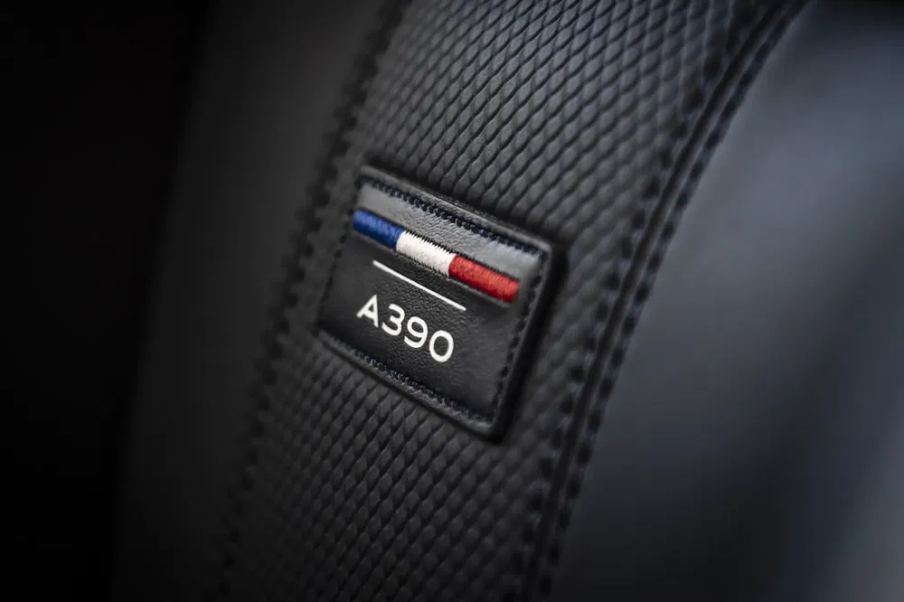Gros plan sur une ceinture de sécurité avec l'insigne A390 et drapeau tricolore français.