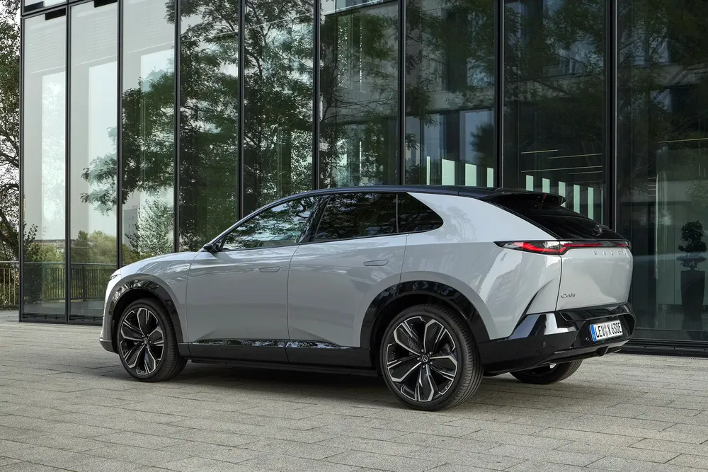 SUV électrique Lynk & Co devant un bâtiment moderne, design élégant et futuriste.