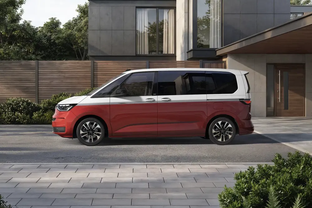 Volkswagen ID. Buzz rouge garé devant une maison moderne.