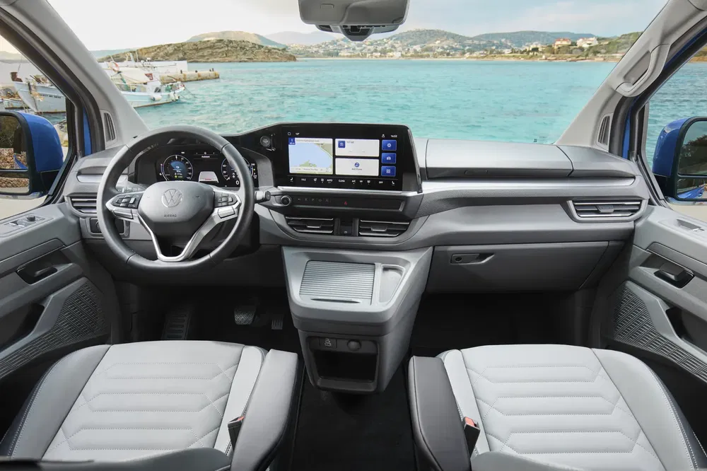 Moderne interieur van de Volkswagen Multivan met zeezicht, digitaal dashboard.