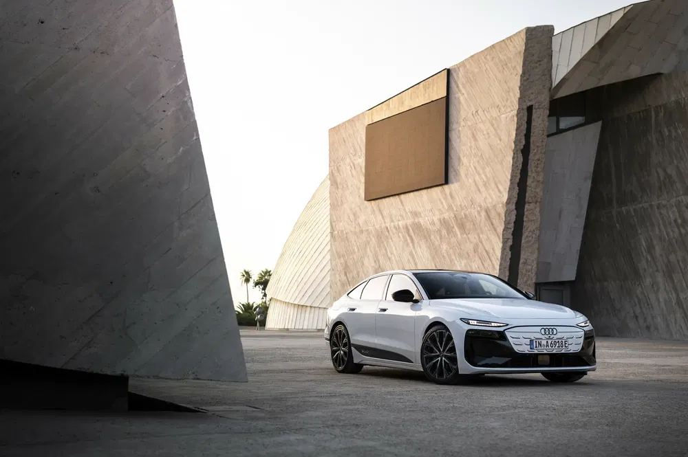 Audi moderne devant architecture minimaliste en béton, capturant design et élégance.