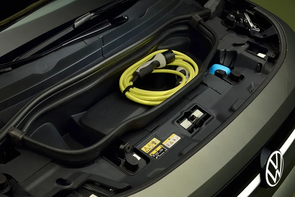Compartiment avant d'une Volkswagen avec câble de recharge électrique jaune.