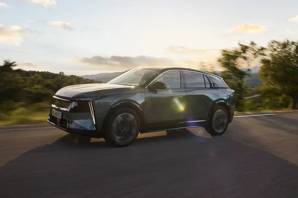 {"fr":"SUV électrique roulant sur route, paysage de campagne ensoleillé à l'arrière-plan.","nl":"Elektrische SUV rijdt op weg bij zonsondergang met landelijk landschap op de achtergrond."}