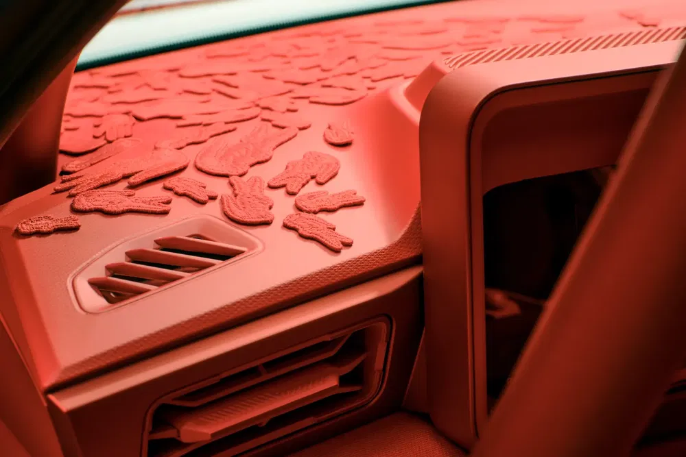 Intérieur futuriste de voiture avec motifs texturés et accents rouges audacieux.