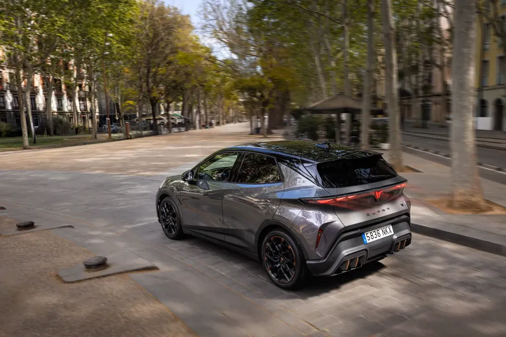 SUV Cupra sur route urbaine bordée d'arbres, finition grise élégante.