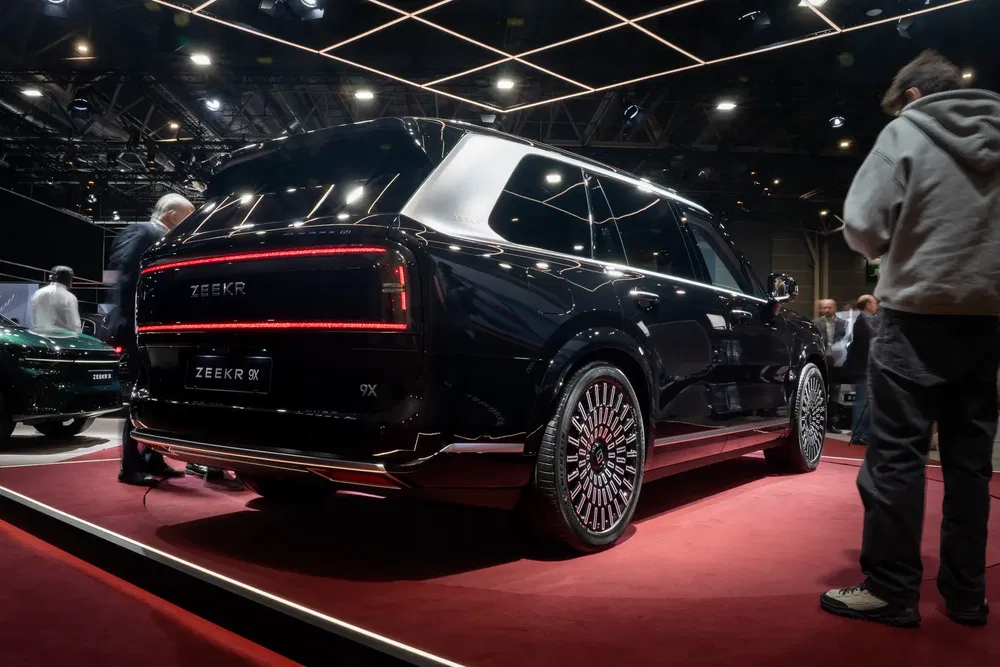SUV Zeekr 9X noir exposé dans une salle d'exposition lumineuse.