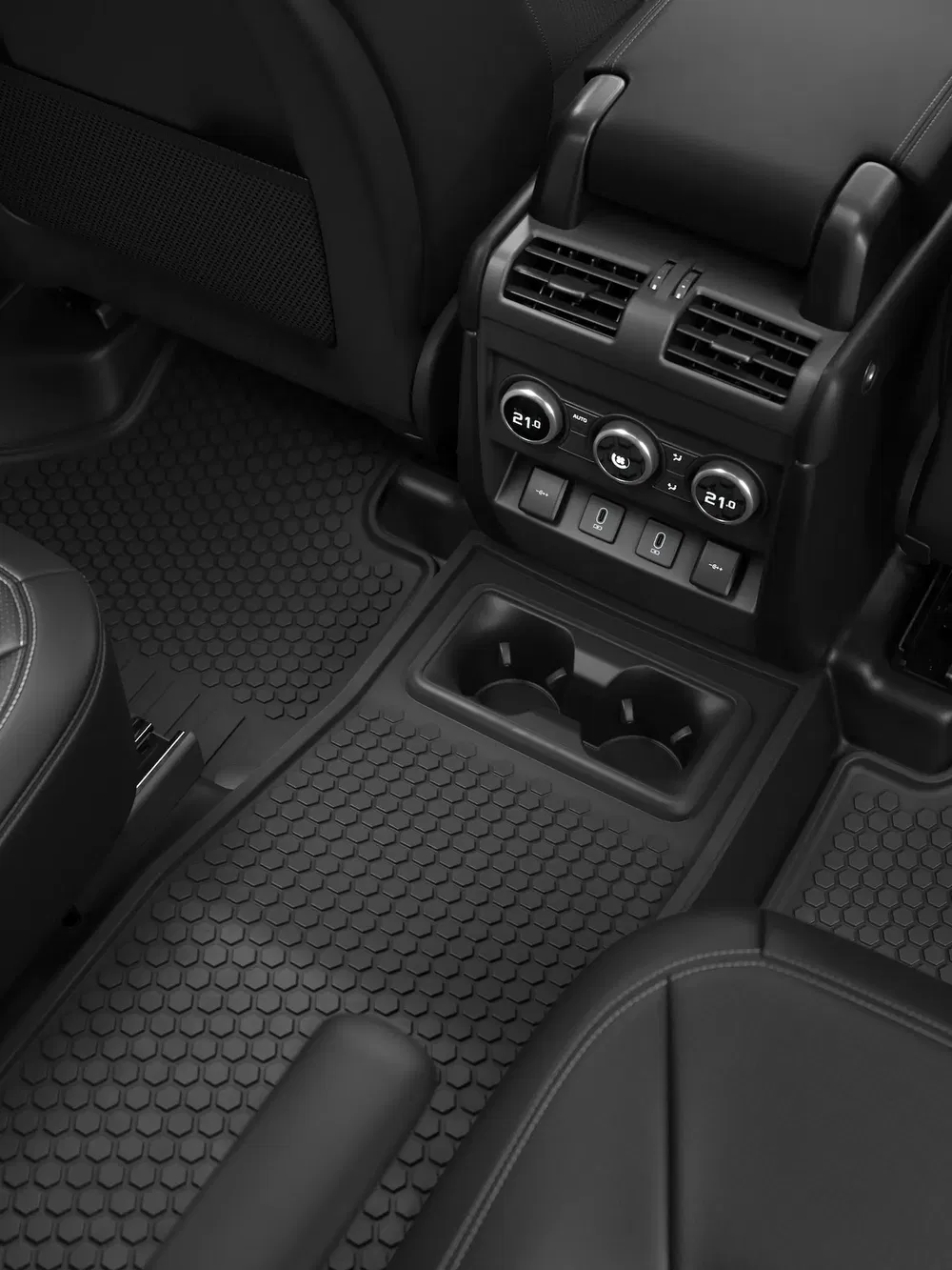Intérieur de voiture avec tapis en caoutchouc et commandes de climatisation arrière modernes.