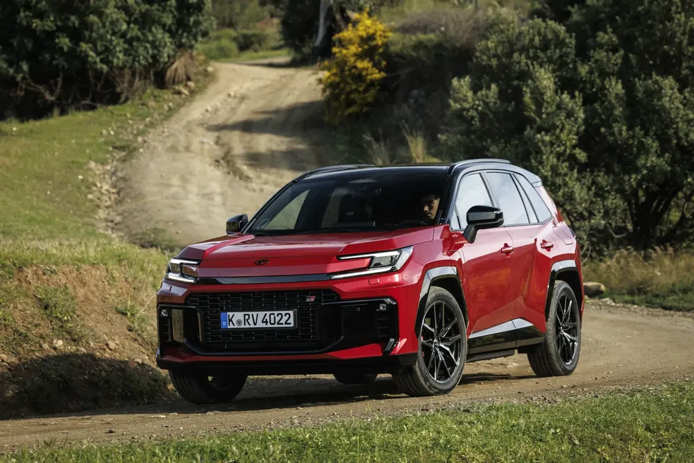 Rode Toyota SUV op zandweg, robuuste en moderne stijl in natuur.