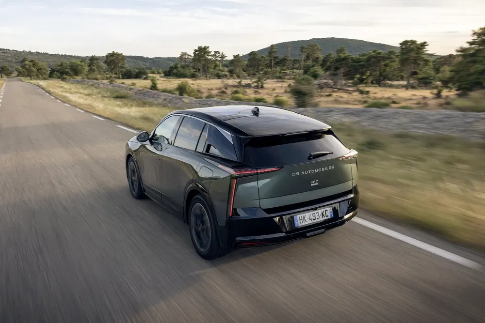 {"fr":"Voiture DS automotrice sur une route de campagne, arrière-plan forestier et ciel dégagé.","nl":"DS-automobiel op landelijke weg, bosrijke achtergrond en heldere lucht."}