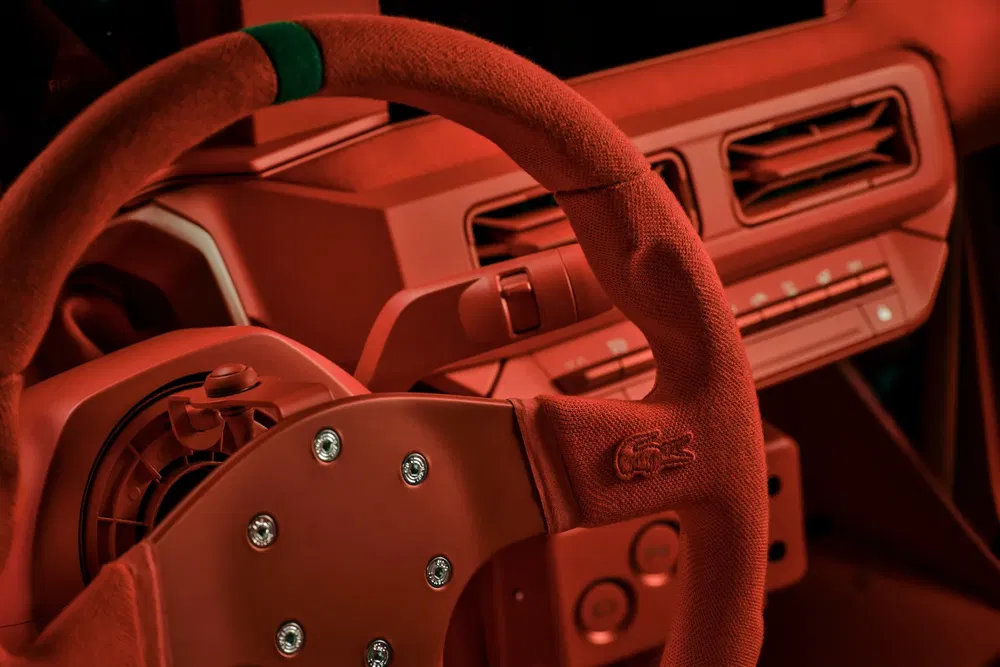 Volant de voiture rouge avec logo Lacoste et tableau de bord minimaliste.