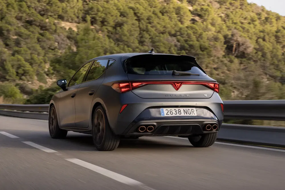 Grijze Cupra Leon op bergweg, achteraanzicht, snelheid en prestaties.