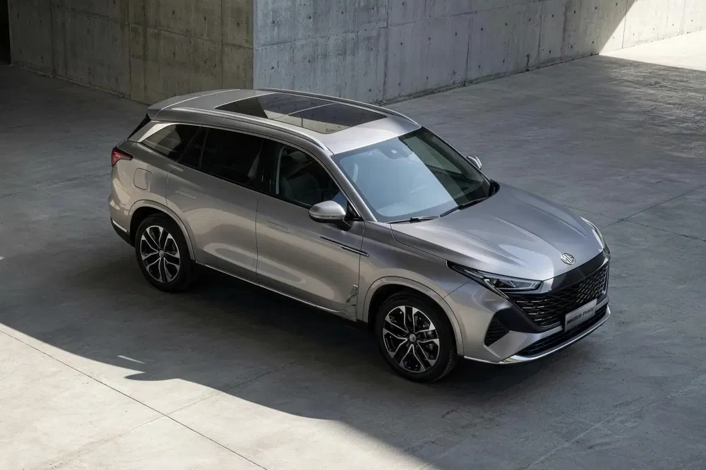 Zilveren Changan SUV geparkeerd op betonnen vloer, met panoramadak en sportvelgen.