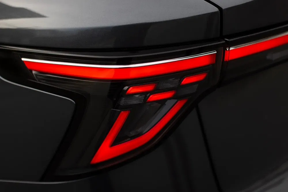 Feu arrière LED moderne d'une voiture, design futuriste avec lignes rouges distinctives.