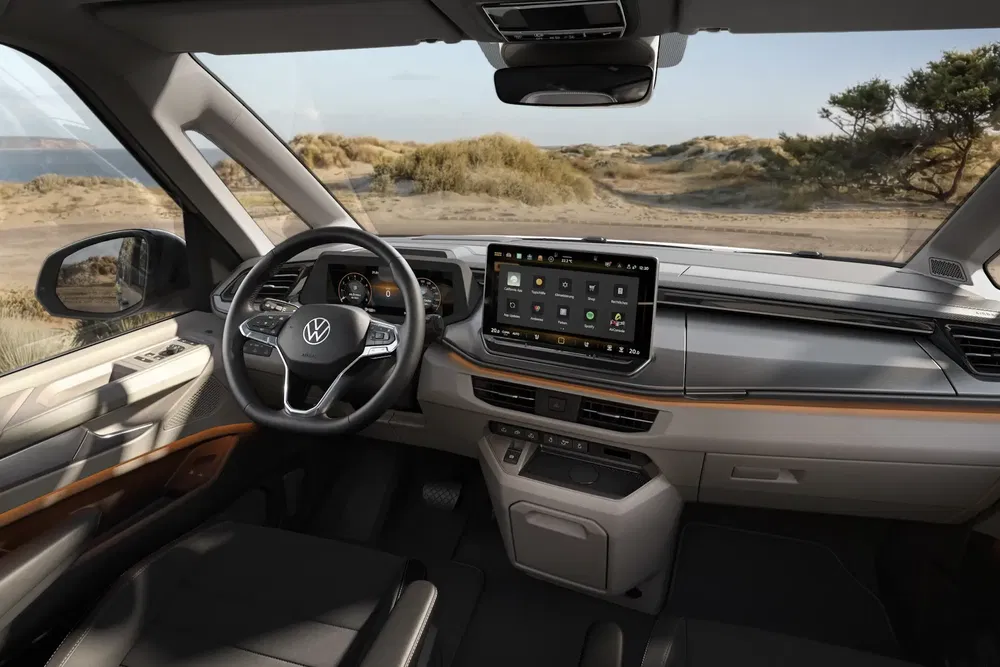 Intérieur moderne du Volkswagen Multivan avec tableau de bord numérique en bord de mer.