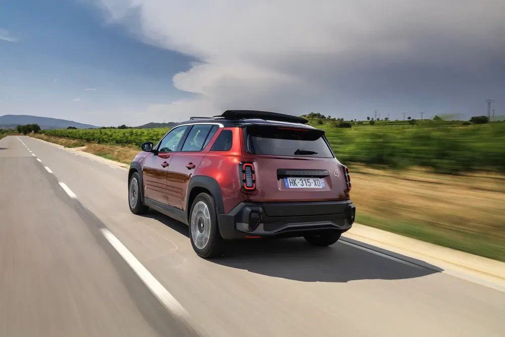 SUV Citroën C3 Aircross rouge voyage sur route ouverte, paysage rural en arrière-plan.