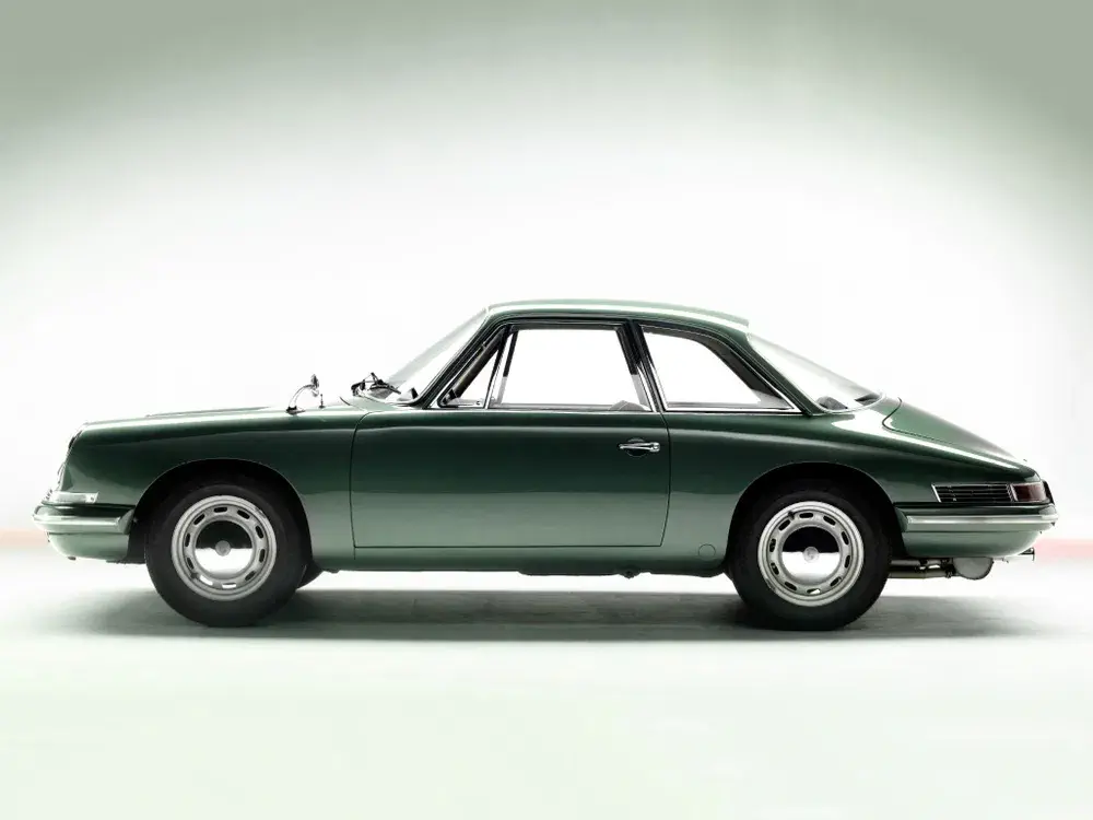 Profil latéral d'une Porsche 911 classique vert foncé sur fond blanc.