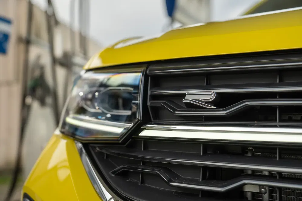 Close-up van een gele Volkswagen R-Line grille, kenmerkende koplamp.