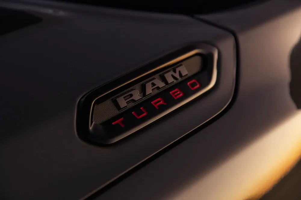 Close-up van het RAM Turbo-embleem op een voertuig bij zonsondergang.