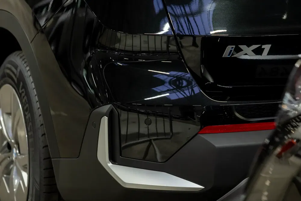 Vue détaillée d'un BMW iX1 noir avec design arrière distinctif et badge iX1.