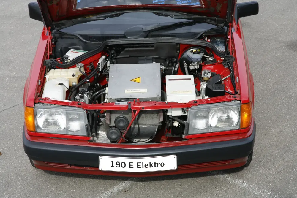 Capot ouvert de la Mercedes 190 E Elektro, montrant le moteur électrique innovant.