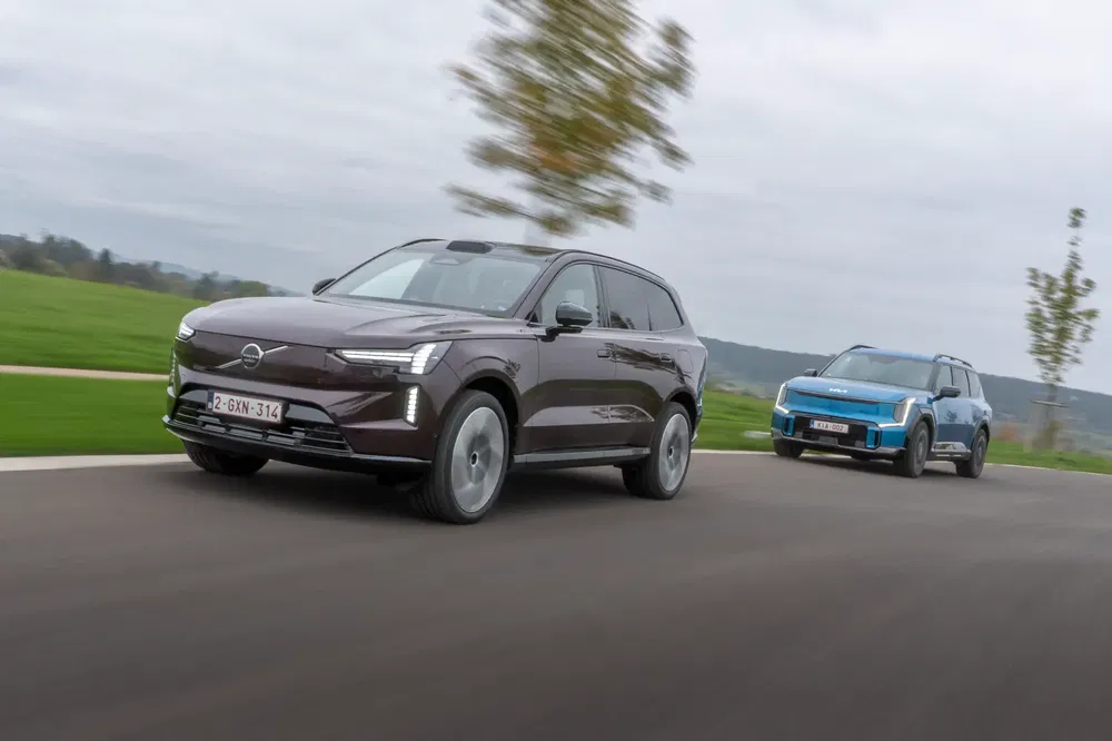 Deux SUV Volvo et Kia se déplaçant rapidement sur une route de campagne.