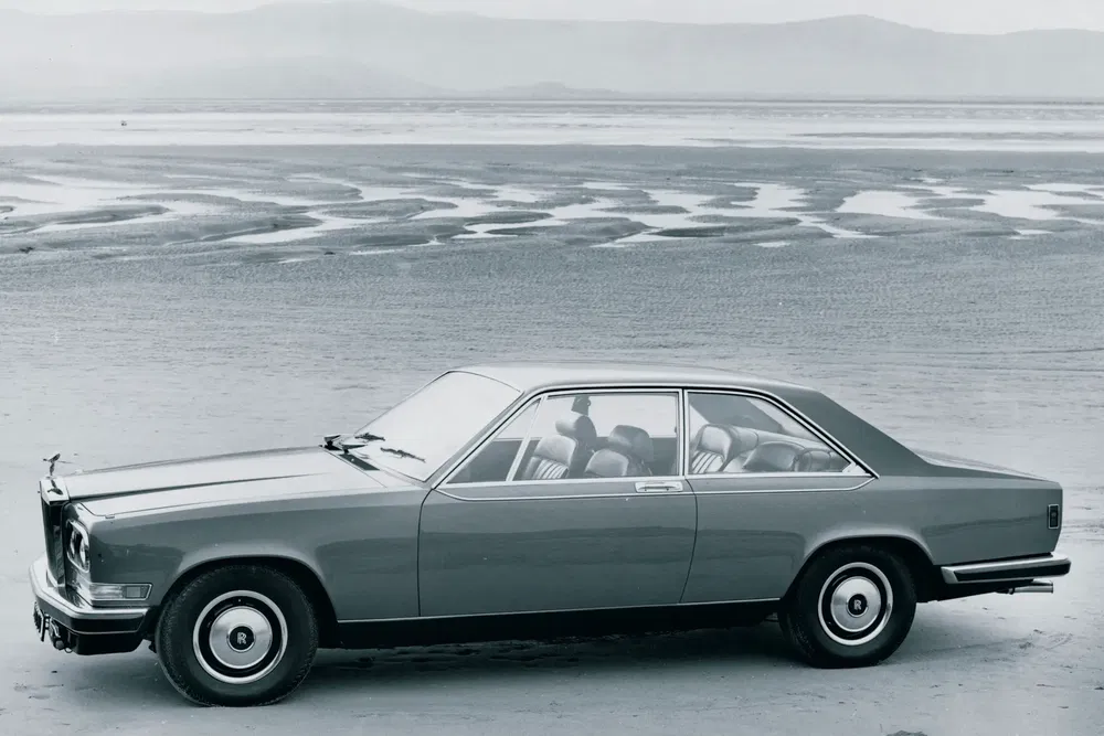 Voiture classique Rolls-Royce Camargue sur plage, design élégant et rétro.