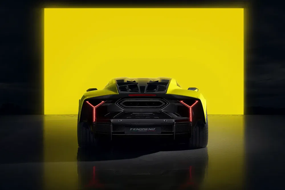 Hypercar jaune devant fond lumineux, design futuriste et aérodynamique marqué.