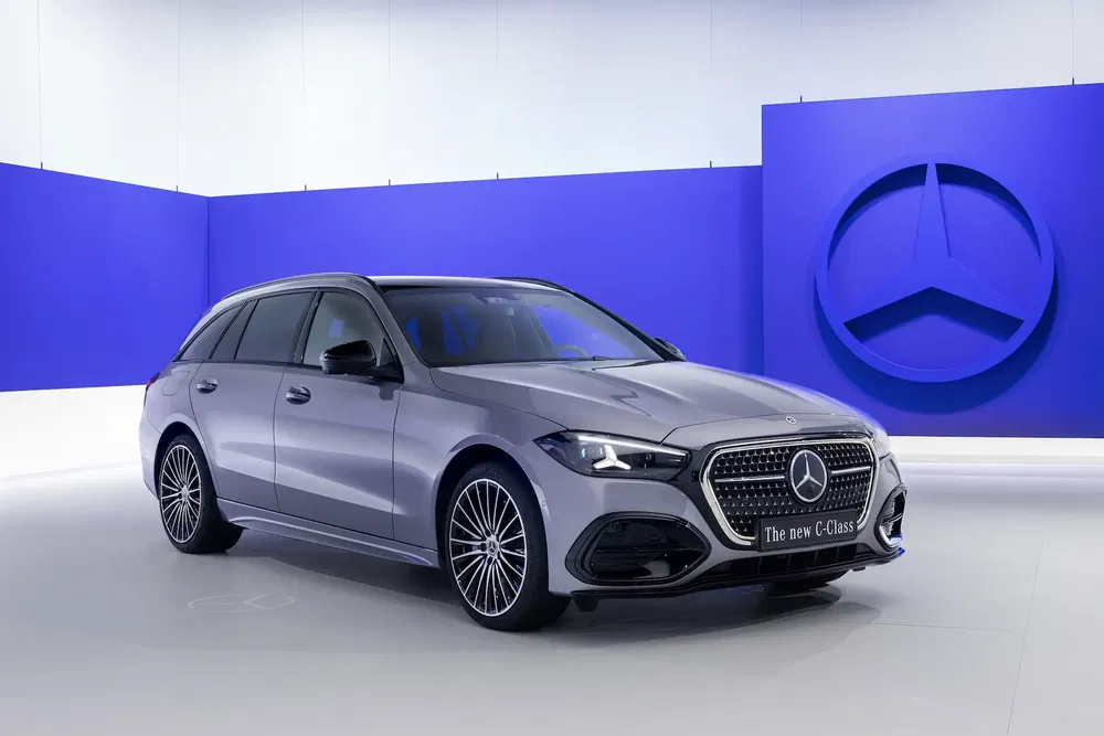 Mercedes-Benz Classe C break gris dans un studio avec logos bleus.