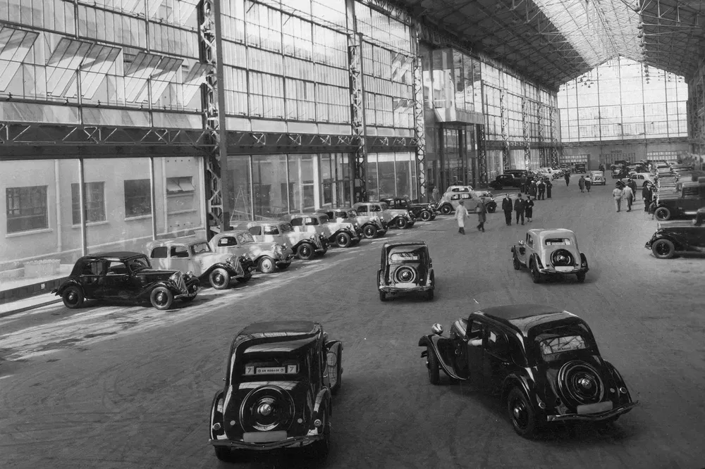 Usine automobile Citroën en 1934 avec plusieurs modèles alignés dans un hangar vitré.