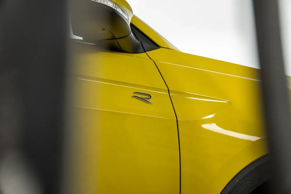 Nabijbeeld van gele Volkswagen met R-logo aan de zijkant.