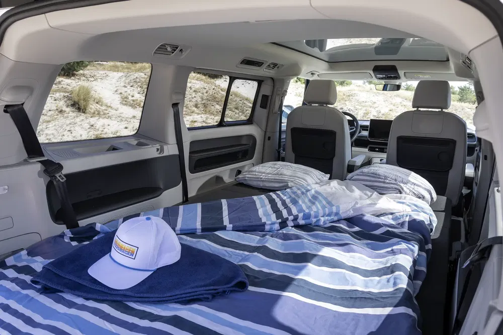 Intérieur d'un van aménagé Volkswagen ID.Buzz avec lit, idéal pour le camping.