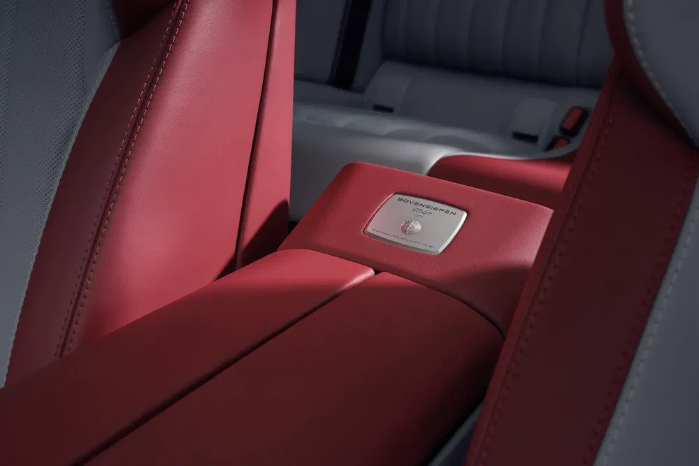 Intérieur luxueux de voiture avec console centrale en cuir rouge et plaque de finition argentée.