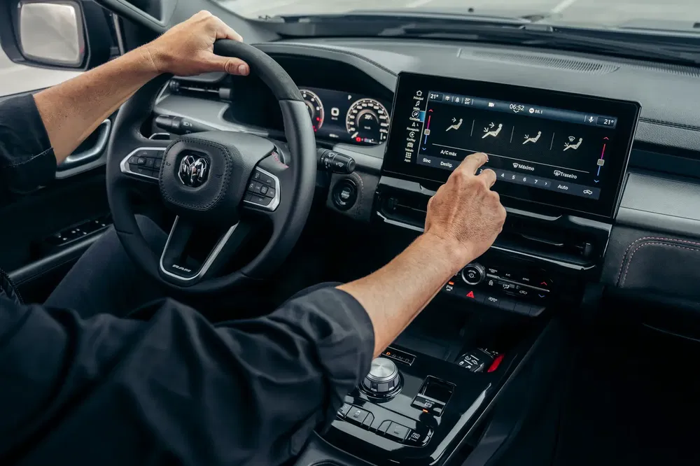 Interieur van een Ram-pick-up met bestuurder die touchscreen gebruikt voor airconditioninginstellingen.