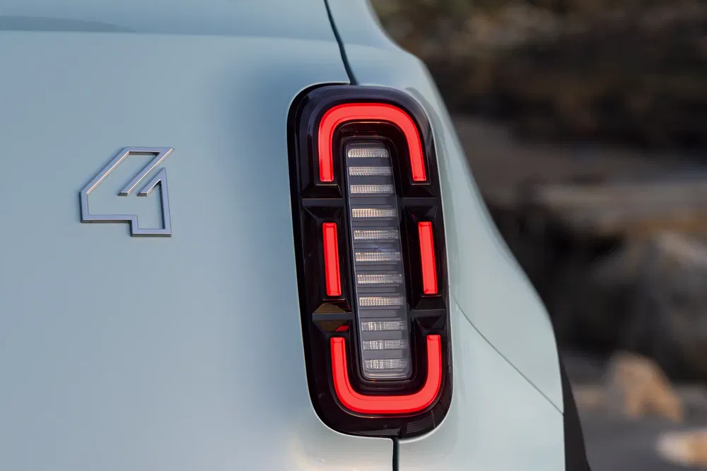 Feu arrière du Renault 4 moderne, design rétro avec logo distinctif sur carrosserie blanche.