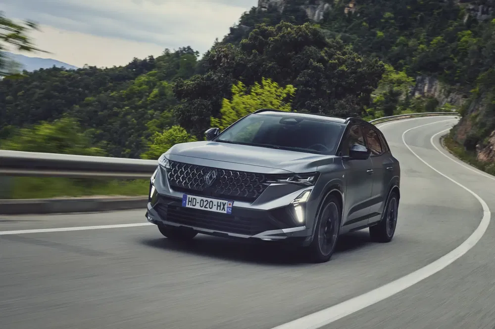 {"fr":"Renault Espace SUV gris sur une route de montagne sinueuse sous un ciel dégagé.","nl":"Grijze Renault Espace SUV op een bochtige bergweg onder een heldere lucht."}