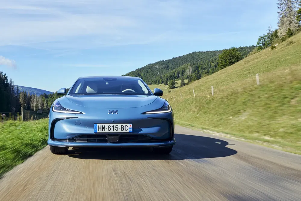 Voiture électrique bleue sur route de campagne, design moderne et élégant.