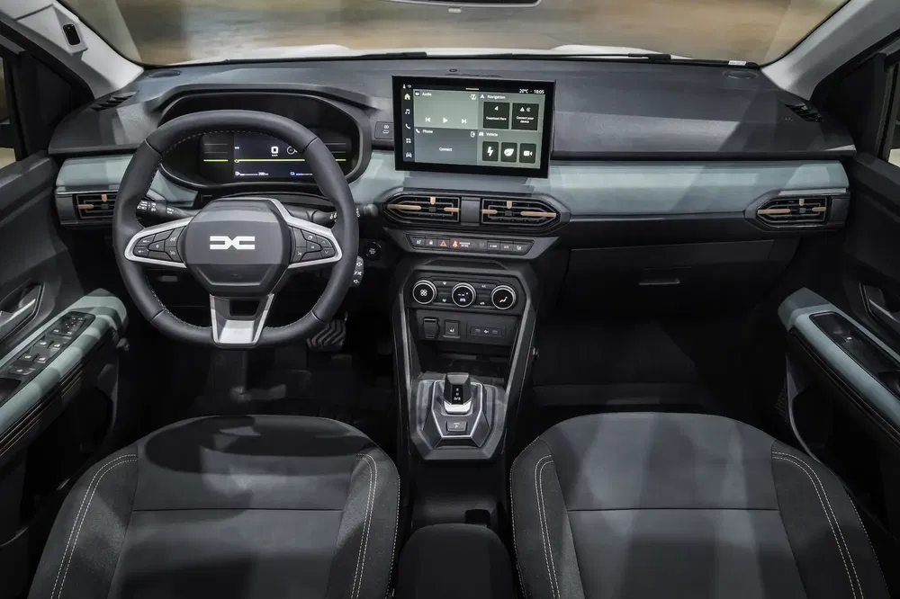 Moderne Dacia auto-interieur met digitaal dashboard en centraal touchscreen.